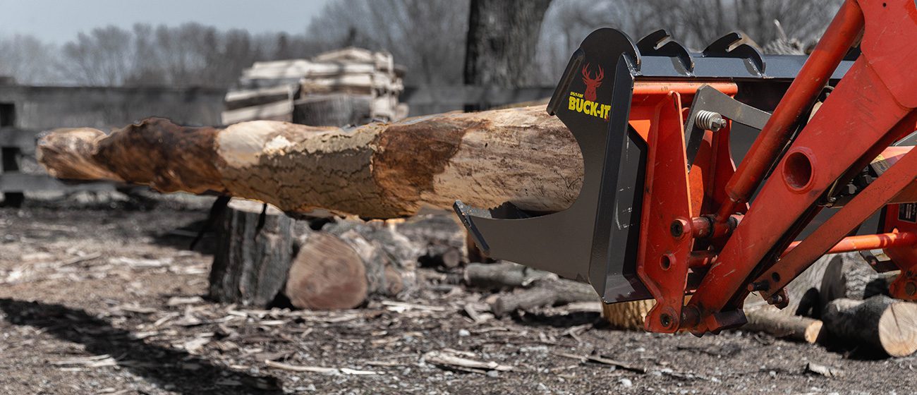 Split-fire Buck-it XL mounted on kubota tractor with 12 foot log